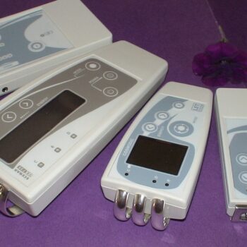 Four white LET Medical SCENAR and COSMODIC therapy devices with silver electrodes.